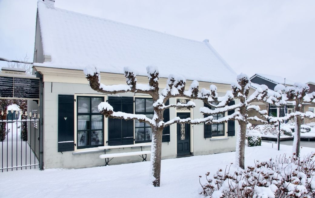 De boomkwekerswoning van het Boomkwekerijmuseum in de sneeuw